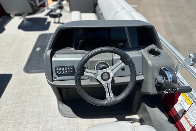 Slide: The Image of 2026 Sun Tracker Sportfish 24 XP3 boat dashboard with steering wheel and controls. - 16