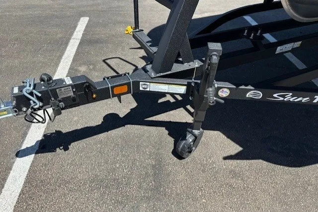 Slide: The Image of Close-up of a boat trailer with a black frame and support wheel in a parking lot. - 13