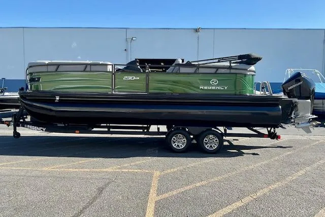 The Image of 2026 Regency 230 DL pontoon boat on trailer, parked outdoors. - 0