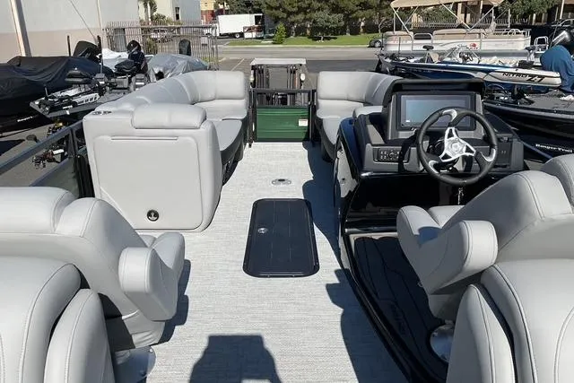 Slide: The Image of 2026 Regency 230 DL pontoon boat interior with plush seating and modern dashboard. - 11