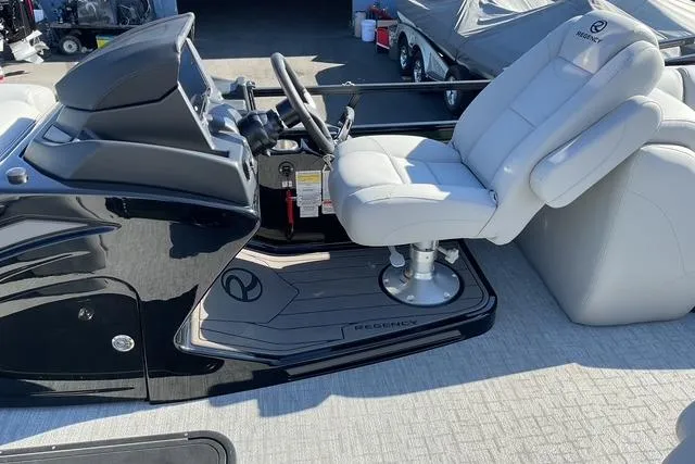 Slide: The Image of Luxurious 2026 Regency 230 DL boat interior with sleek black console and plush captain's chair. - 5