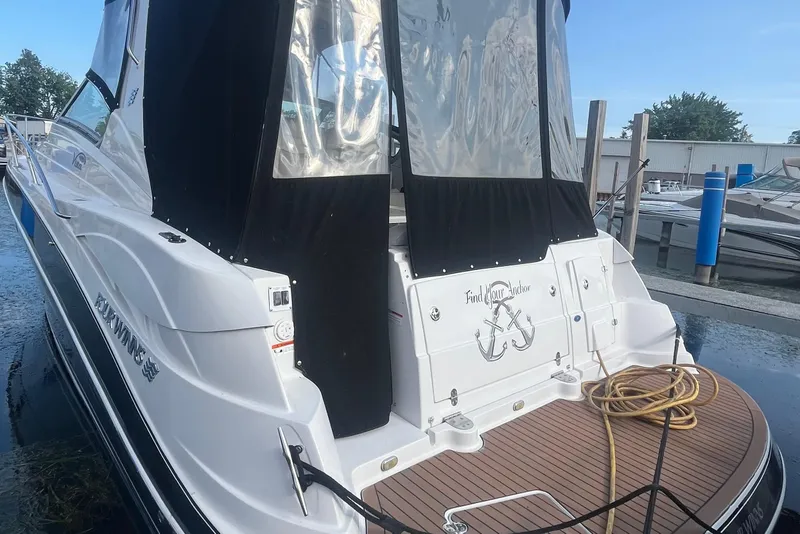 Slide: The Image of 2006 Four Winns 318 Vista boat docked, featuring a sleek design and covered cockpit area. - 6
