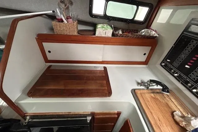 Slide: The Image of 1989 Rampage 28 Sportsman boat interior with wooden cabinetry and compact kitchen area. - 10