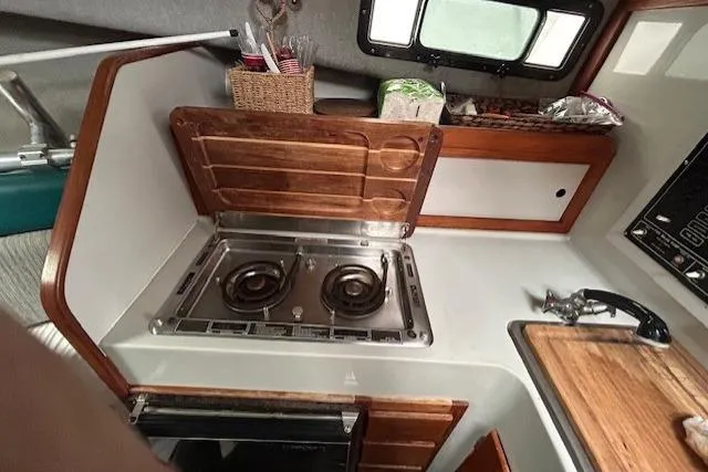 Slide: The Image of Compact kitchen area in a 1989 Rampage 28 Sportsman boat with stove and sink. - 11