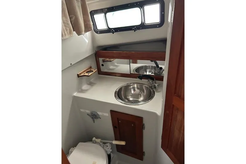 Slide: The Image of 1989 Rampage 28 Sportsman boat bathroom with sink, mirror, and toilet. - 12