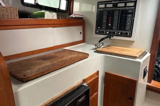 Slide: The Image of 1989 Rampage 28 Sportsman boat interior with wooden countertops and control panel. - 8