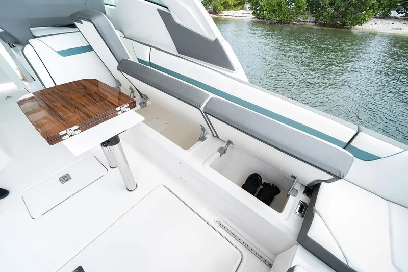 Slide: The Image of Manufacturer Provided Image: 2020 Tiara Sport 34 LX boat interior with storage compartments and wooden table. - 12