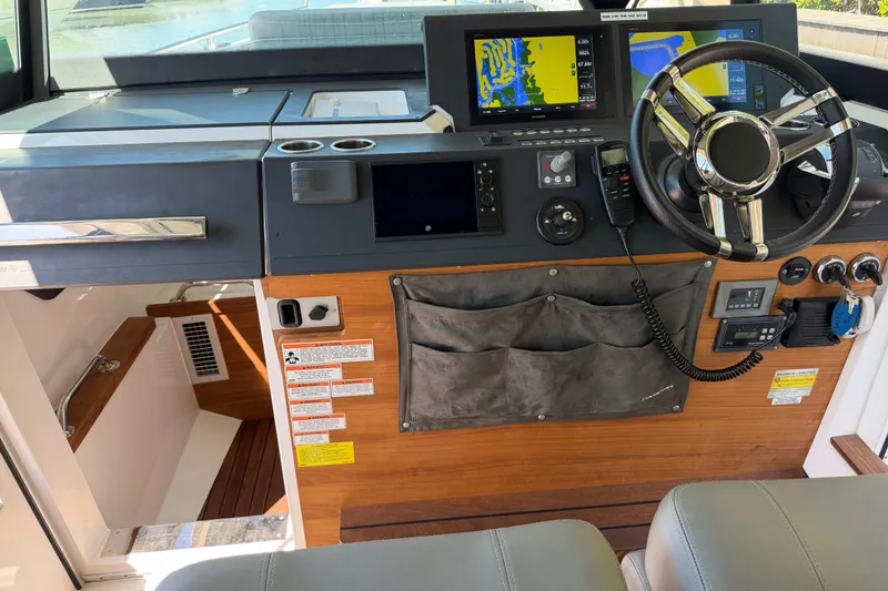 Slide: The Image of 2018 Axopar 37 Cabin helm with navigation screens and steering wheel. - 13