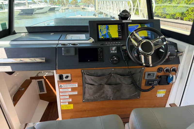 Slide: The Image of 2018 Axopar 37 Cabin helm with navigation screens and steering wheel. - 14