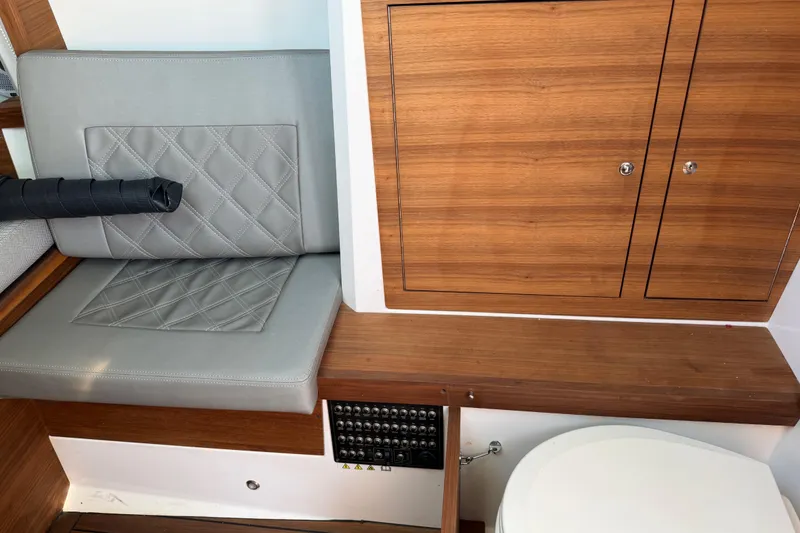 Slide: The Image of Interior of 2018 Axopar 37 Cabin featuring seating, wooden cabinetry, and a control panel. - 24