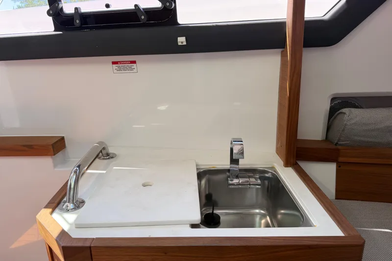 Slide: The Image of 2018 Axopar 37 Cabin interior sink with modern faucet and wooden accents. - 25