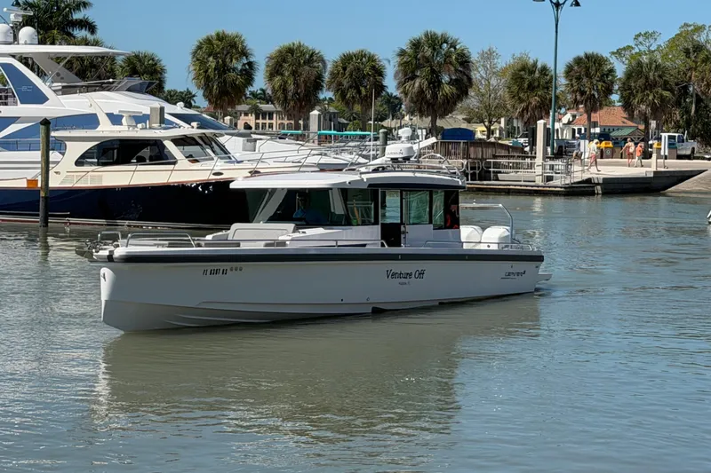 Slide: The Image of 2018 Axopar 37 Cabin boat docked in a marina with palm trees. - 3
