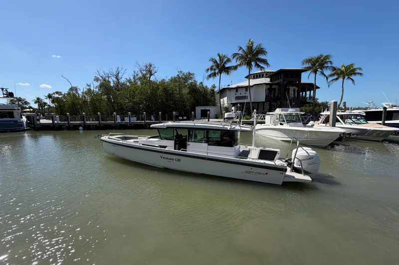 Slide: The Image of 2018 Axopar 37 Cabin boat docked in sunny marina with palm trees. - 4