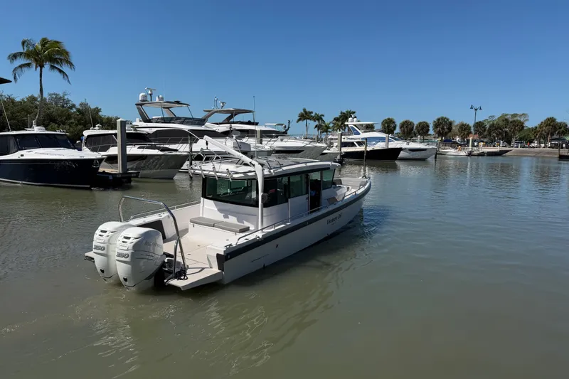 Slide: The Image of 2018 Axopar 37 Cabin boat docked in a marina under clear blue skies. - 5