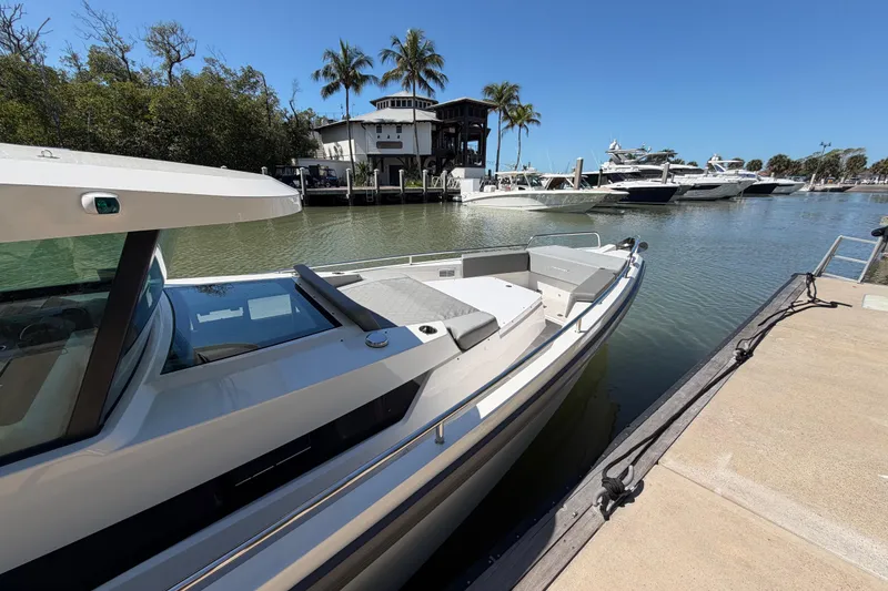Slide: The Image of 2018 Axopar 37 Cabin boat docked in a sunny marina with palm trees. - 6
