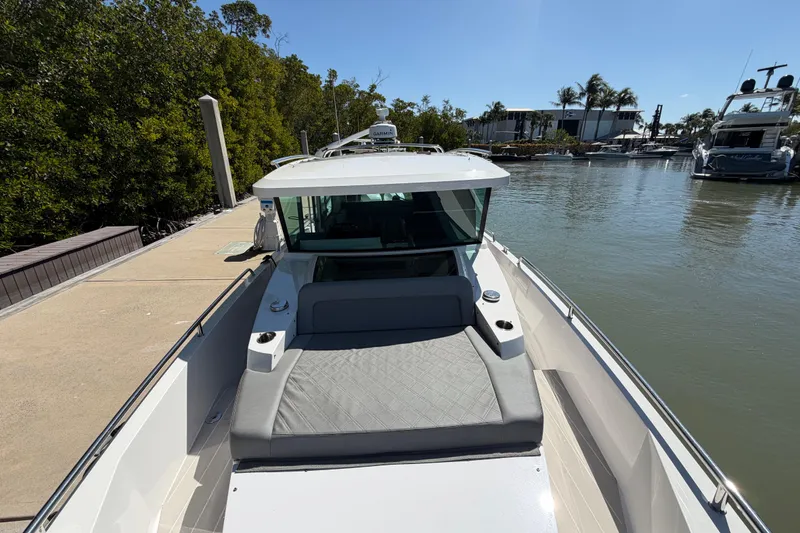 Slide: The Image of 2018 Axopar 37 Cabin boat docked by lush greenery and calm waters. - 9