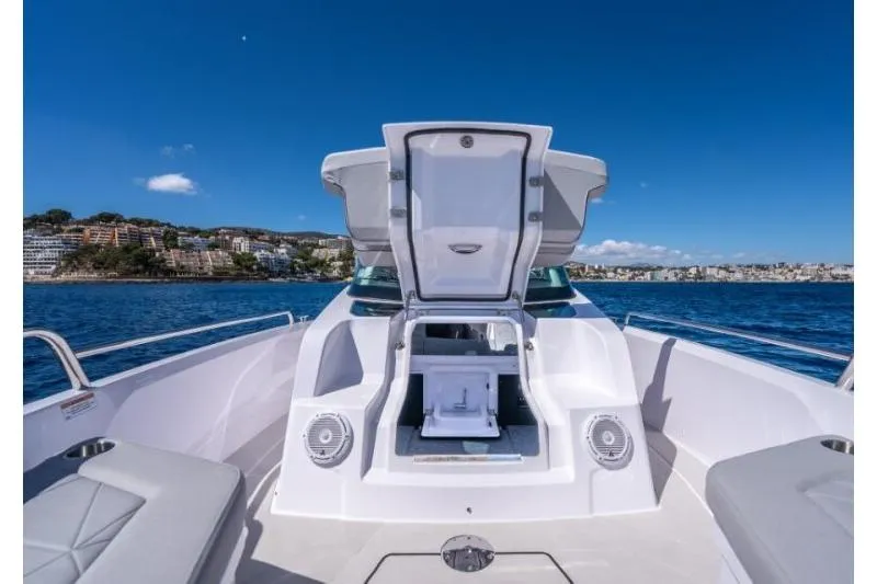 Slide: The Image of 2027 Axopar 29 Sun-Top boat with open storage, cruising on a sunny day. - 5