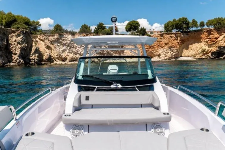 Slide: The Image of 2027 Axopar 29 Sun-Top boat on clear water near rocky coastline. - 6