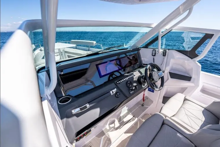 Slide: The Image of 2027 Axopar 29 Sun-Top boat interior with modern dashboard and steering wheel. - 8
