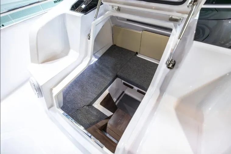Slide: The Image of Interior cabin view of 2027 Axopar 29 Sun-Top boat, featuring seating and storage. - 9