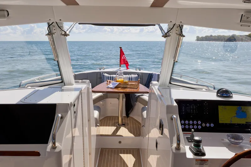 Slide: The Image of Luxury MJM 38x yacht interior with ocean view, featuring a dining area and navigation controls. - 10