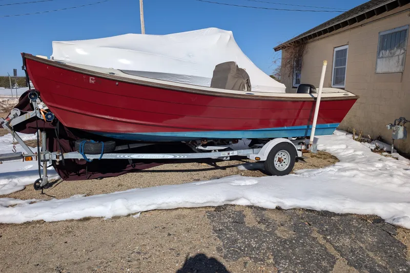 The Image of Red 1988 Belkov skiff on trailer, parked on snowy ground near a building. - 1