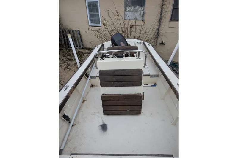 Slide: The Image of 1988 Custom Skiff boat interior with wooden seats and steering console. - 5