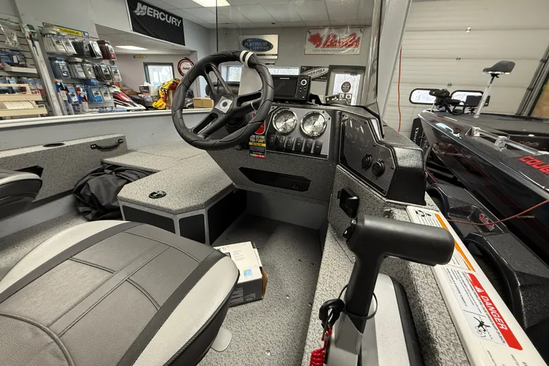 Slide: The Image of 2025 Lund 1675 Adventure SS boat interior with steering wheel and dashboard controls. - 9