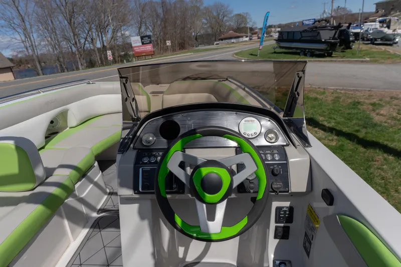 Slide: The Image of 2017 Starcraft Crossover 231 SCX IO SURF boat interior with green accents and steering wheel. - 10