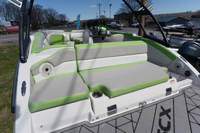 Slide: The Image of 2017 Starcraft Crossover 231 SCX IO SURF boat with green and gray seating, docked outdoors. - 16