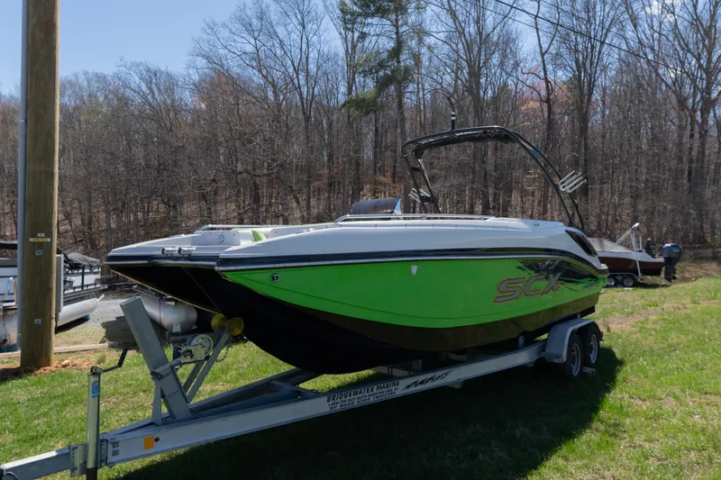 Slide: The Image of 2017 Starcraft Crossover 231 SCX IO SURF boat on trailer, green and black design. - 3