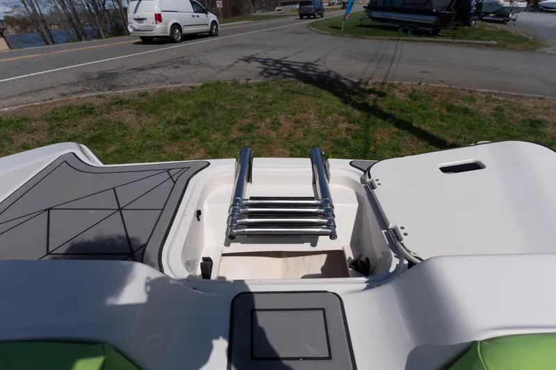 Slide: The Image of 2017 Starcraft Crossover 231 SCX IO SURF boat with open storage compartment and ladder. - 7