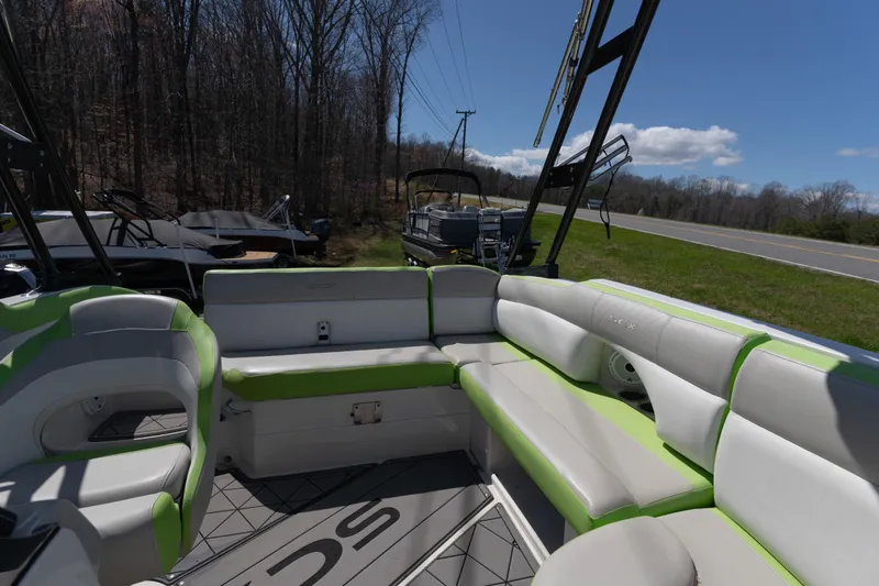 Slide: The Image of 2017 Starcraft Crossover 231 SCX IO SURF boat interior with green and white seating. - 8