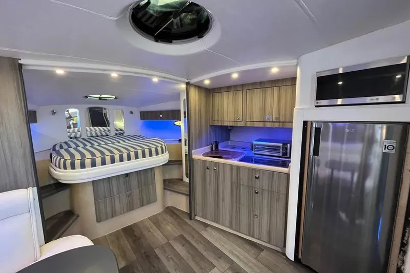 Slide: The Image of Luxurious interior of 2001 Cruisers Yachts 3870 Express with modern kitchen and cozy sleeping area. - 13