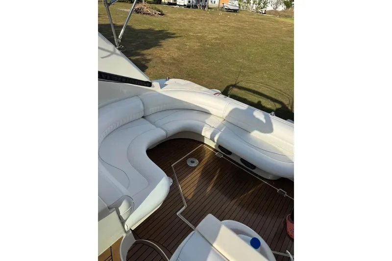 Slide: The Image of 2001 Cruisers Yachts 3870 Express interior with white seating and wooden flooring. - 6