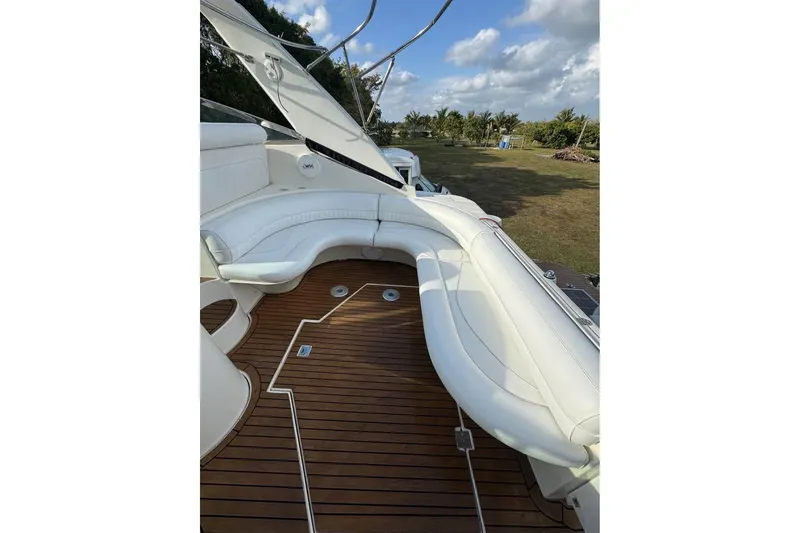 Slide: The Image of 2001 Cruisers Yachts 3870 Express with white seating and teak deck, outdoors. - 7
