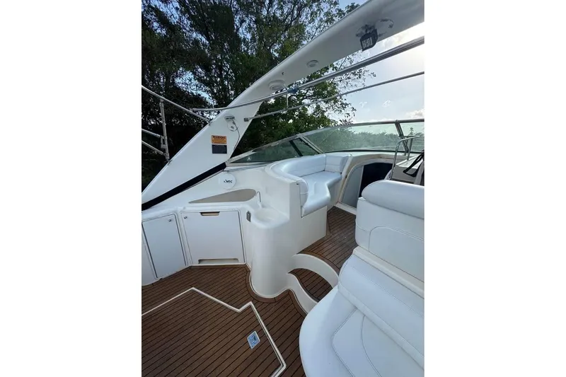 Slide: The Image of 2001 Cruisers Yachts 3870 Express interior with white seating and wooden flooring. - 8