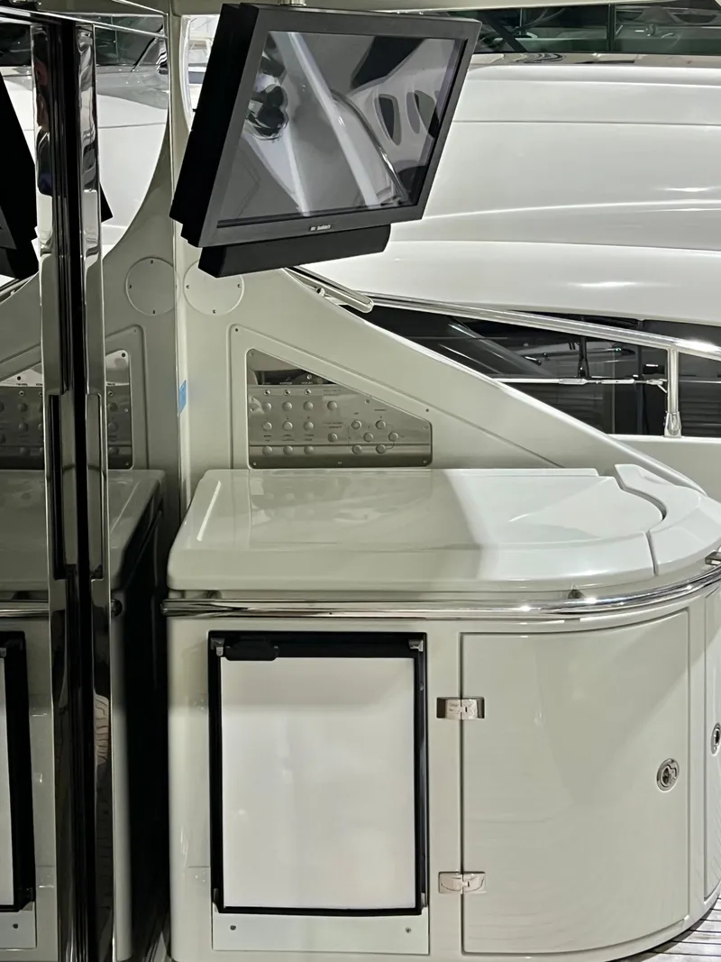 Slide: The Image of Interior of a 2010 Azimut 62S yacht with a mounted TV and storage cabinet. - 11