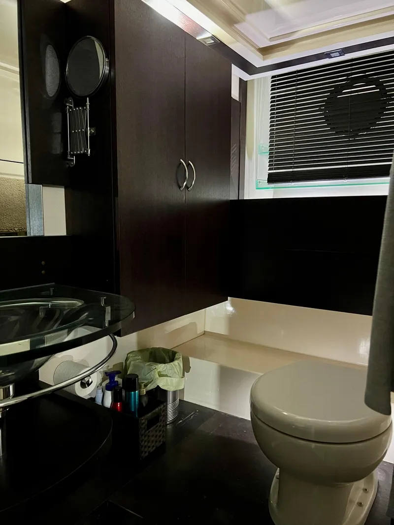 Slide: The Image of Modern bathroom in a 2010 Azimut 62S yacht with sleek fixtures and dark cabinetry. - 31