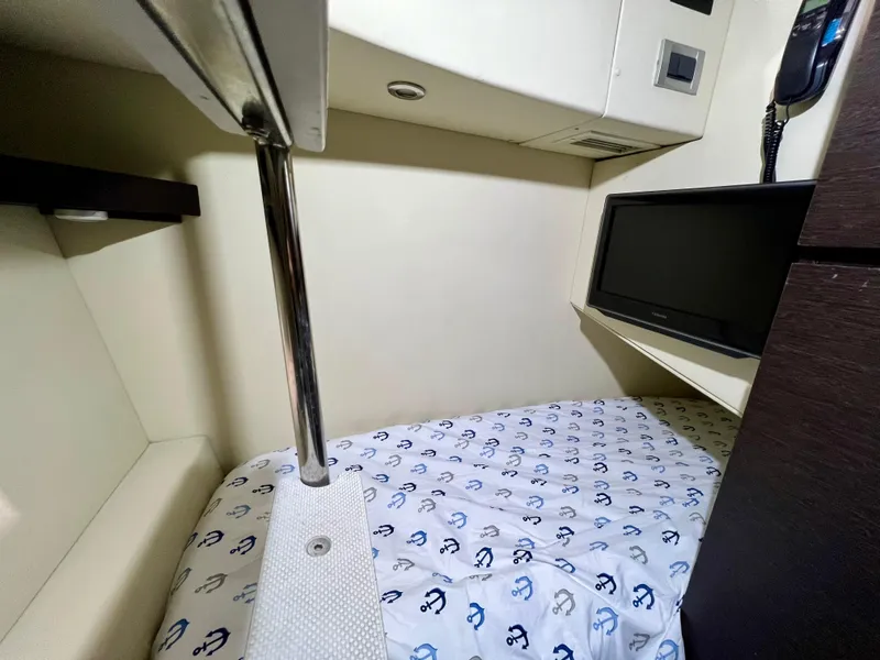 Slide: The Image of Cozy cabin bed in a 2010 Azimut 62S yacht with TV and anchor-patterned bedding. - 42