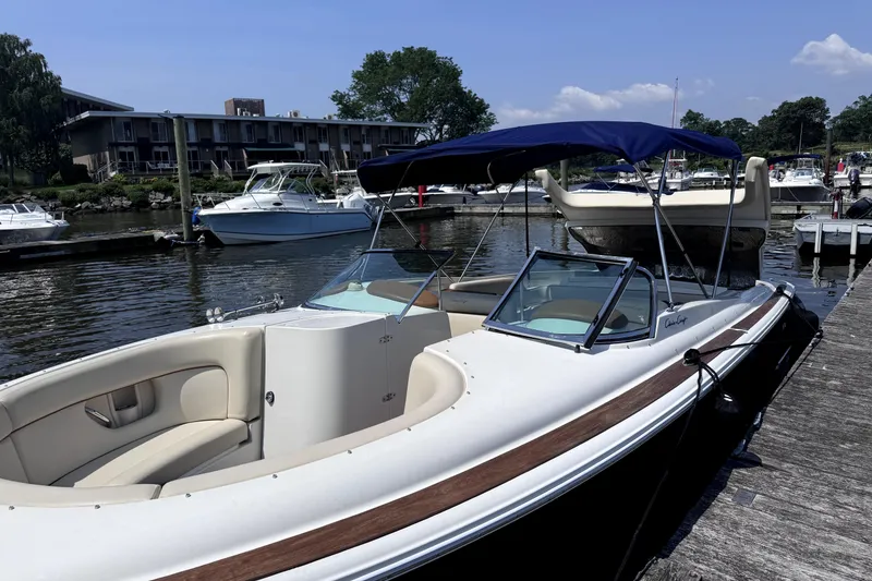 Slide: The Image of 2008 Chris-Craft Launch 28 boat docked at marina with blue canopy. - 2
