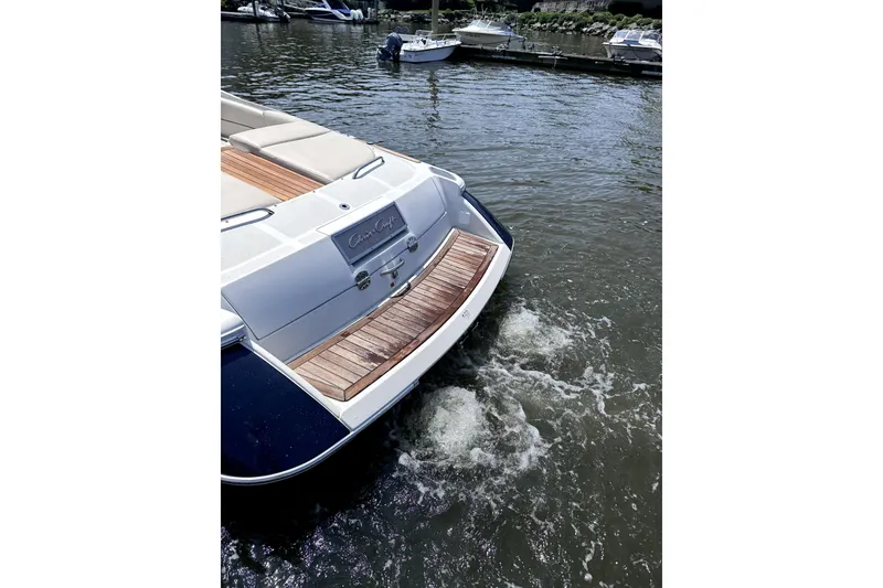 Slide: The Image of 2008 Chris-Craft Launch 28 boat on water, showcasing elegant wooden deck and sleek design. - 4