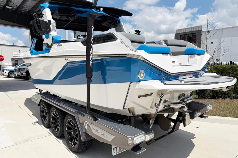 Slide: The Image of 2025 Nautique Super Air Nautique G25 Paragon boat on trailer, blue and white design. - 3