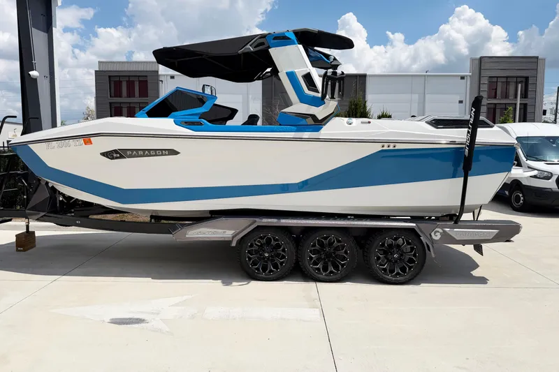The Image of 2025 Nautique Super Air Nautique G25 Paragon boat on trailer, blue and white design. - 0