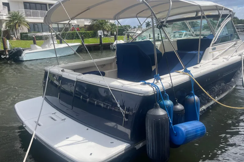 Slide: The Image of 2001 Tiara Yachts 2900 Coronet docked, featuring blue fenders and a spacious deck. - 10