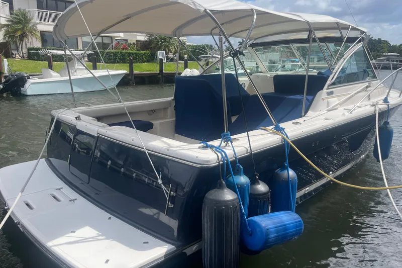 Slide: The Image of 2001 Tiara Yachts 2900 Coronet docked, featuring blue fenders and canopy. - 11