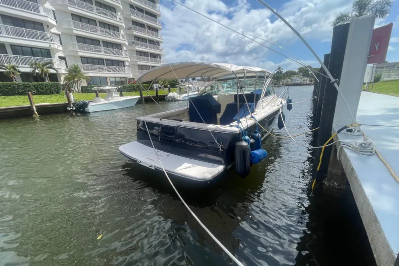 Slide: The Image of 2001 Tiara Yachts 2900 Coronet docked near waterfront apartments under a sunny sky. - 12