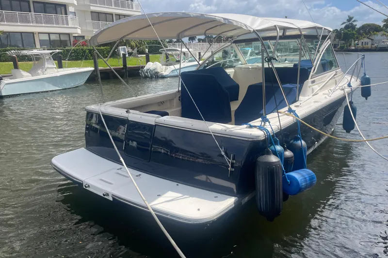 Slide: The Image of 2001 Tiara Yachts 2900 Coronet docked, featuring a spacious deck and protective canopy. - 13