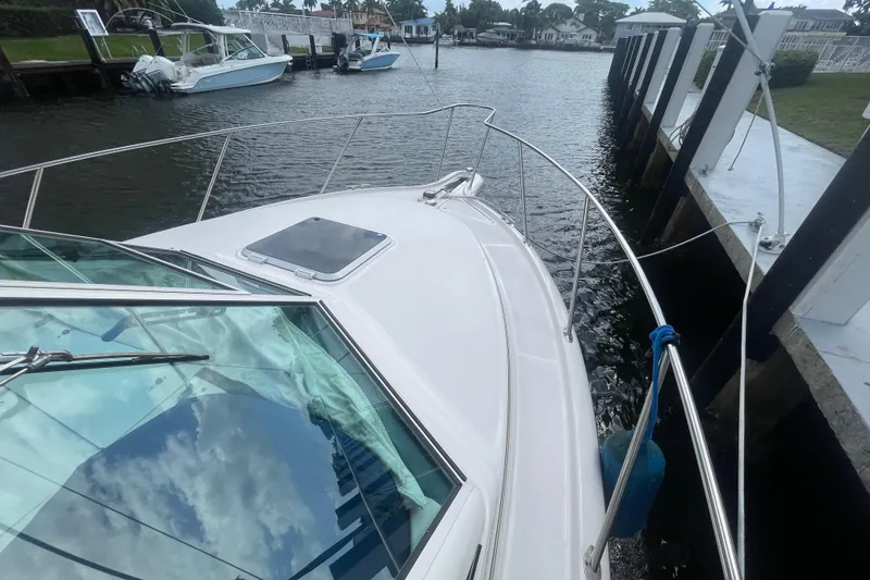 Slide: The Image of 2001 Tiara Yachts 2900 Coronet docked in a serene waterfront setting. - 17