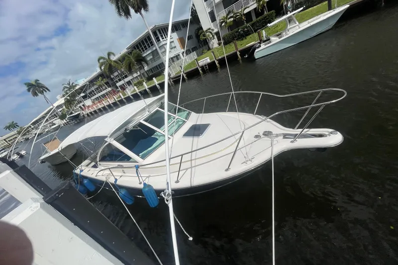 Slide: The Image of 2001 Tiara Yachts 2900 Coronet docked by palm trees and waterfront buildings. - 4